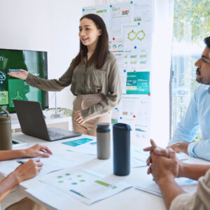 Asian woman lead young group of multiethnic businesspeople in team meeting, using laptop computer for ESG topic presentation on monitor. Sustainable business practice, people work at home concept